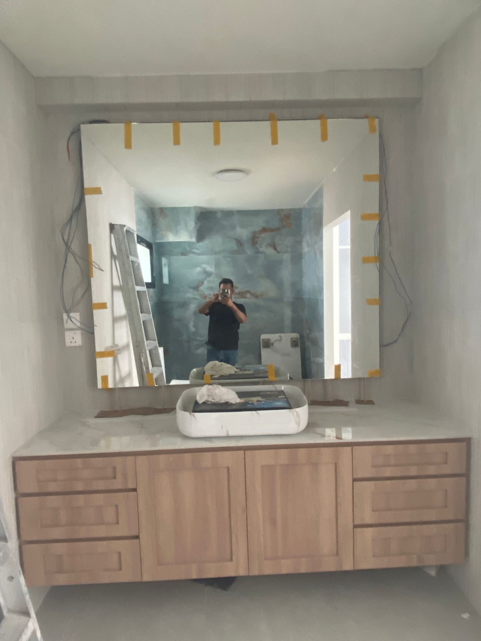 Bathroom with marble-effect wall tiling and a floating timber vanity
