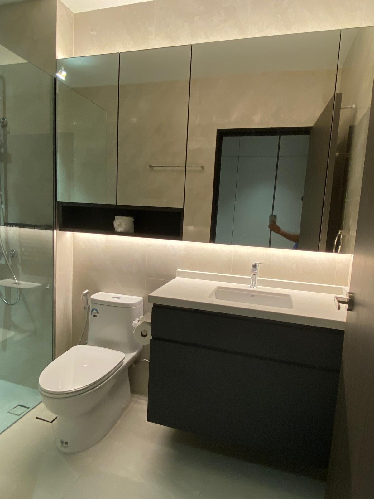 Bathroom with dark floating vanity and backlit mirror cabinet