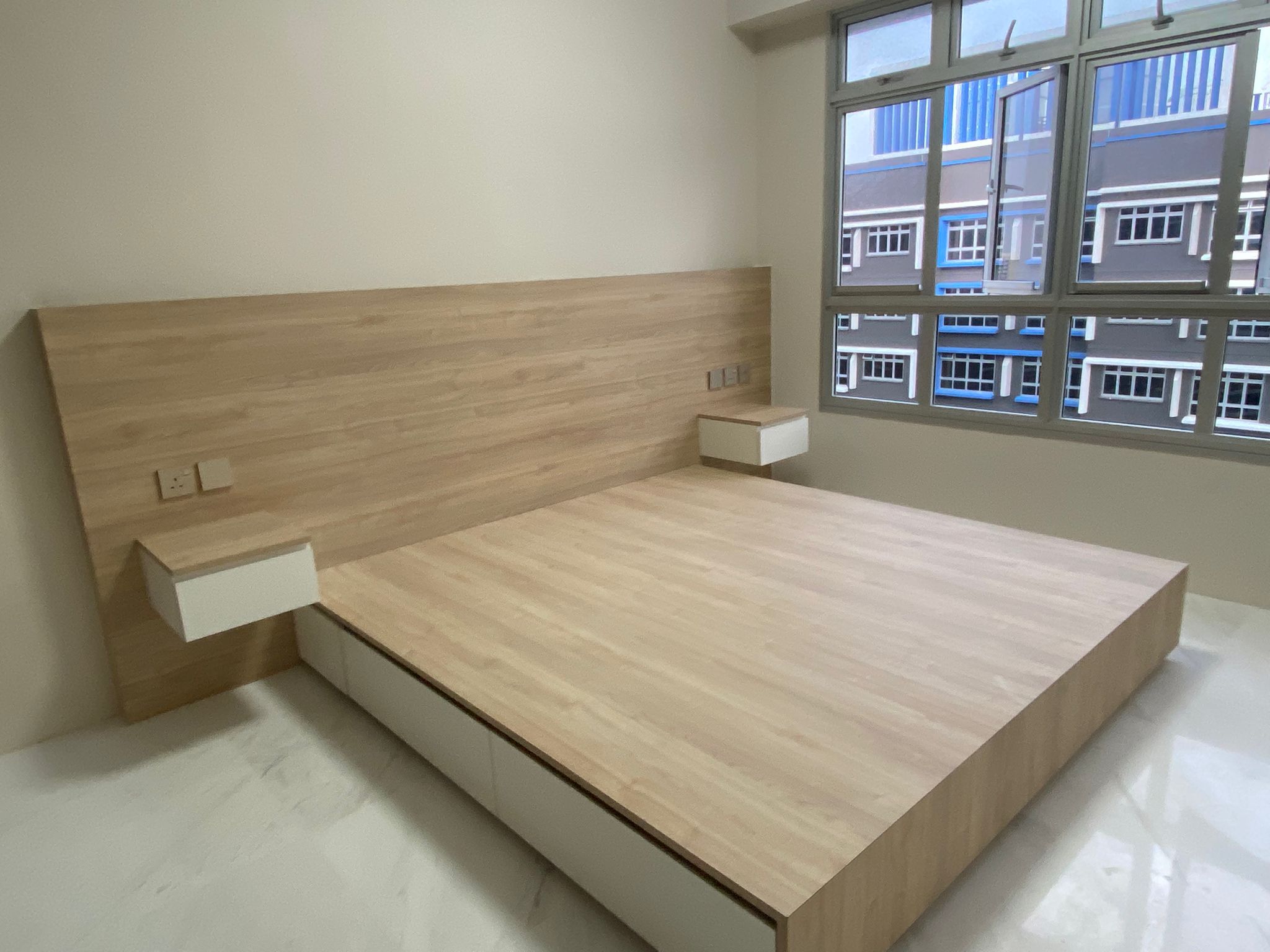 Custom platform bed with built-in nightstands in a bright bedroom