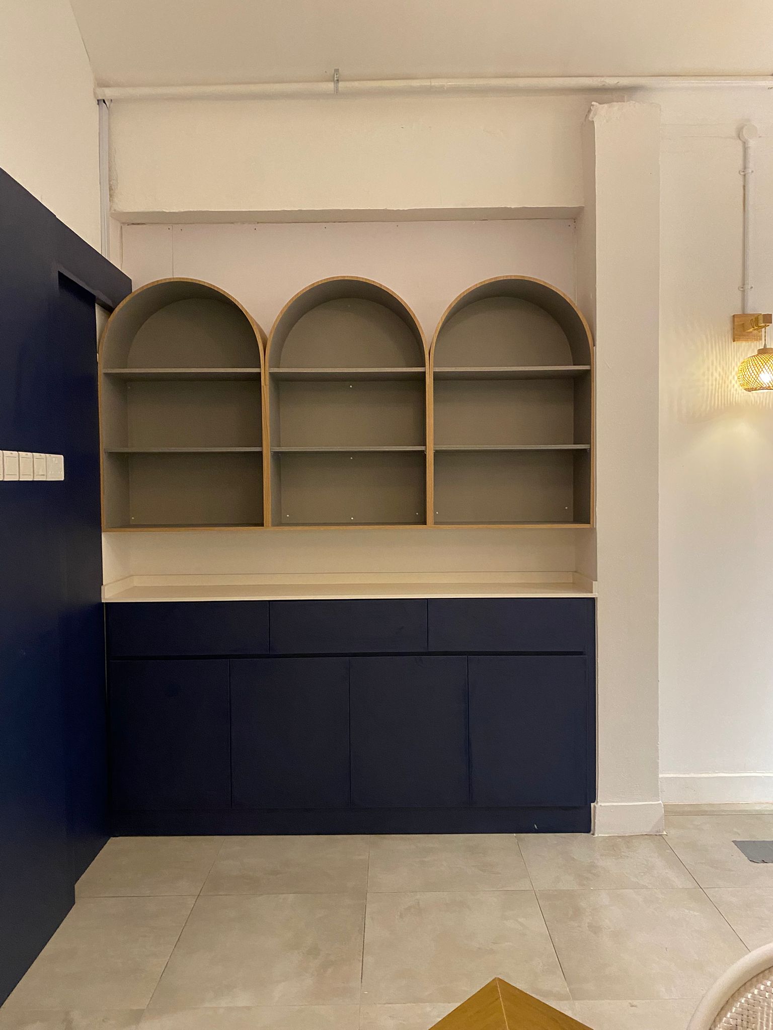 Custom arched display shelving in cream and navy carpentry