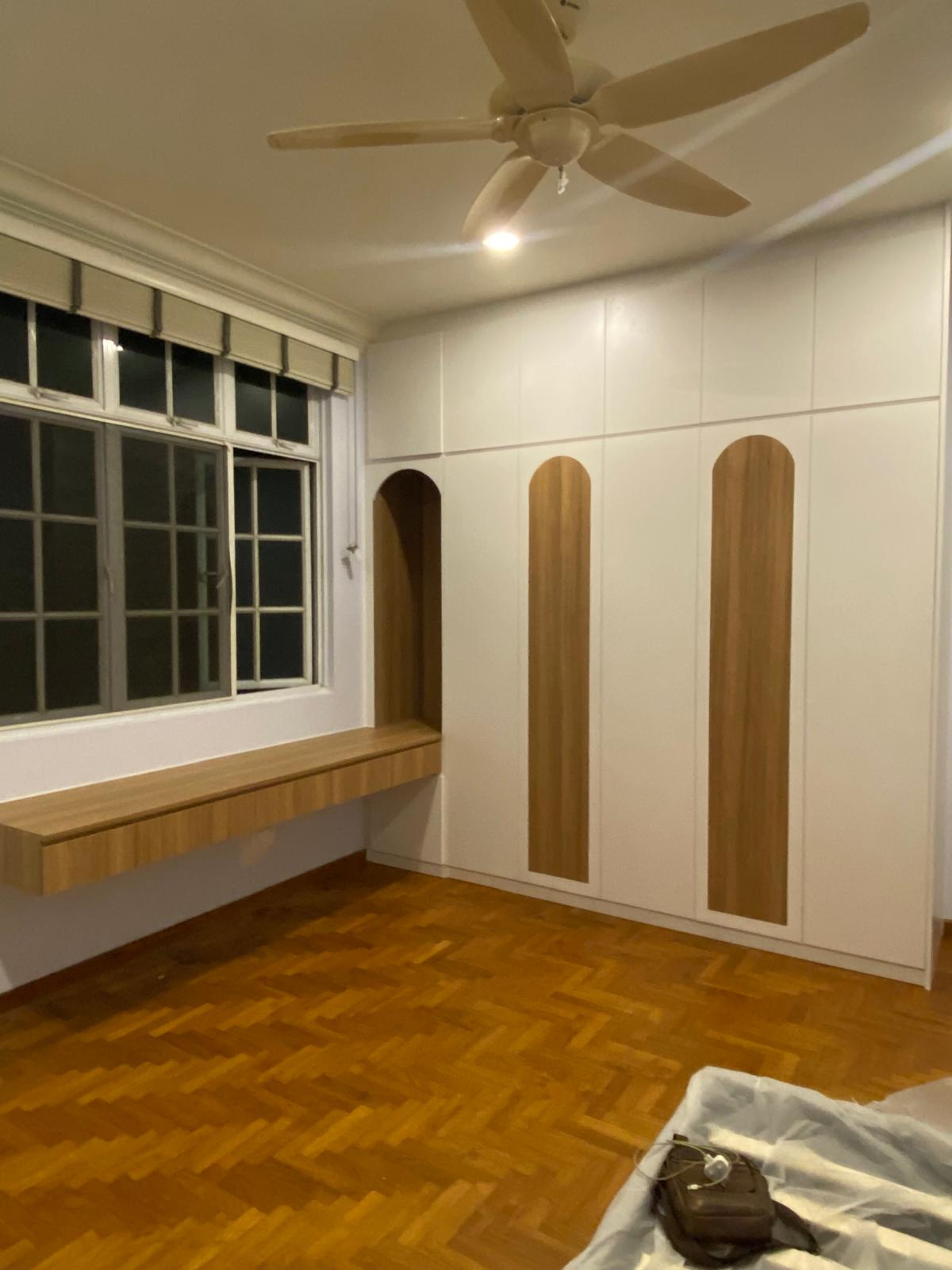 White wardrobe with arched wood inlay panels beside a window bench