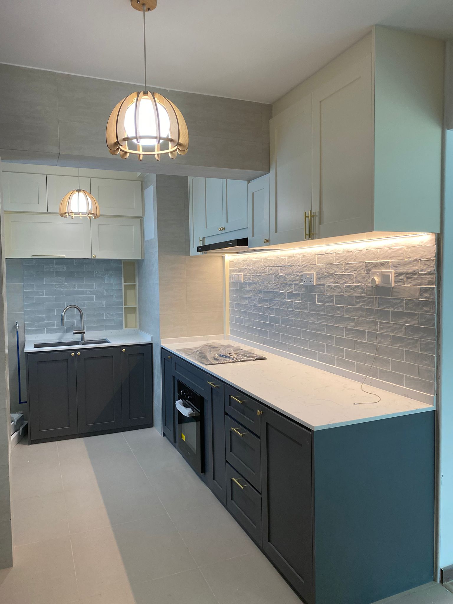 Galley kitchen with white subway tile backsplash and navy base cabinets